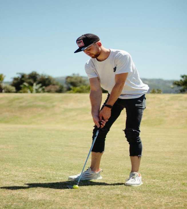 A golfer playing in the sunny field